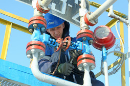 Оператор по добыче нефти и газа Дмитрий Яковлев проводит технологический осмотр запорной арматуры