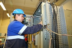 Электромонтер Антон Ротт проводит подключение контрольного кабеля цепи защиты компрессора