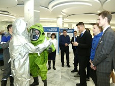Молодым посетителям выставки "Ошибки человечества" демонстрируются теплоотражающий костюм и костюм химической защиты