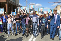 Молодые газовики с портретами фронтовиков ООО "Газпром добыча Оренбург" в шествии "Бессмертного полка"