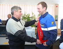 Владимир Чунихин (слева) вручает ленту с надписью "Триллион!" сменному мастеру УКПГ-14 Кириллу Шабловскому