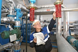 Оператор теплового пункта УЭСП Ринат Каримов производит осмотр клапана регулировки подачи горячей воды на теплообменник