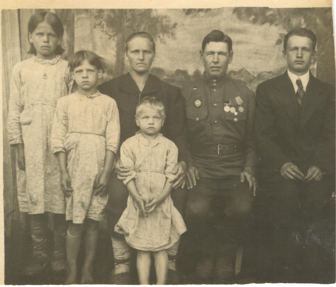 Семья Семеновых: (слева направо) дочери Татьяна, Анна, Клавдия, в центральном ряду слева супруга Фатиния Ивановна, Григорий Михайлович (с медалями), сын Иван (крайний справа), 1945 год